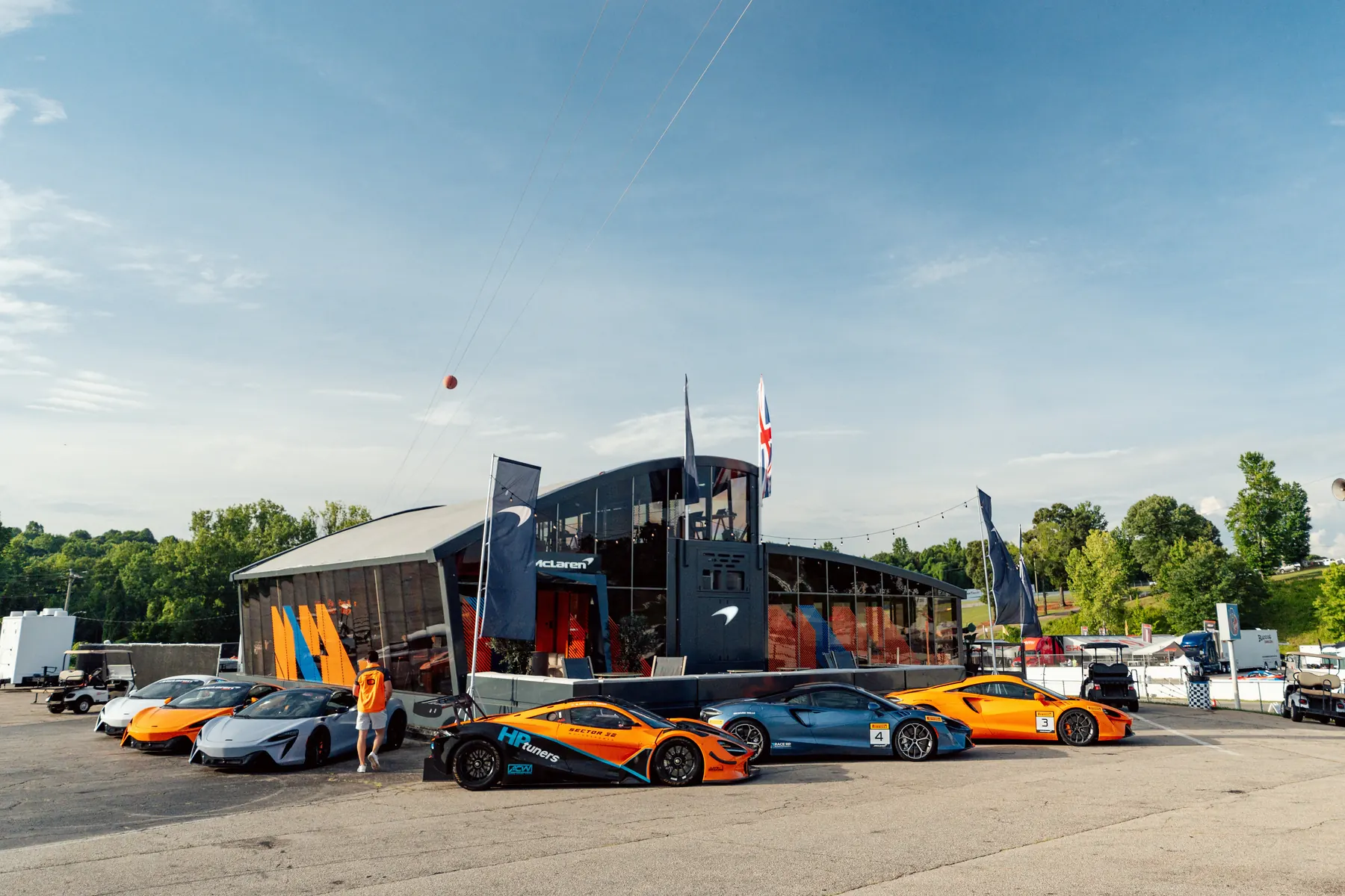 The McLaren paddock with cars parked outside the hospitality suite